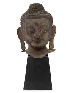 Burmese Lacquer Buddha Head Sculpture: Burmese Lacquer Buddha Head Sculpture, with glass eyes and remnants of polychrome and gilding, atop a black lacquered wood stand. Overall: 20.5" H x 10.25" W x 6.5" D. Provenance: From a New York