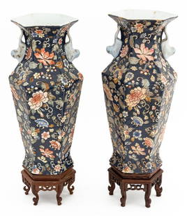 Chinese Hexagonal Porcelain Vases, Pair: Pair of Chinese Hexagonal Porcelain Vases, each with blue ground, floral motif, and foo dog form handles, carved and pierced wood stands. Overall: 19.25" H x 7.5" Diameter. Provenance: From the Collec