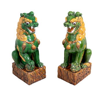 Chinese Sancai Glazed Ceramic Foo Lions, Pair: Pair of Chinese Sancai Glazed Ceramic Foo Lions, each realistically modeled with raised paw on auspicious symbols, on a rectangular rockwork base. 23.5" H x 10" W x 12" D. Keywords: Asian Art, China,