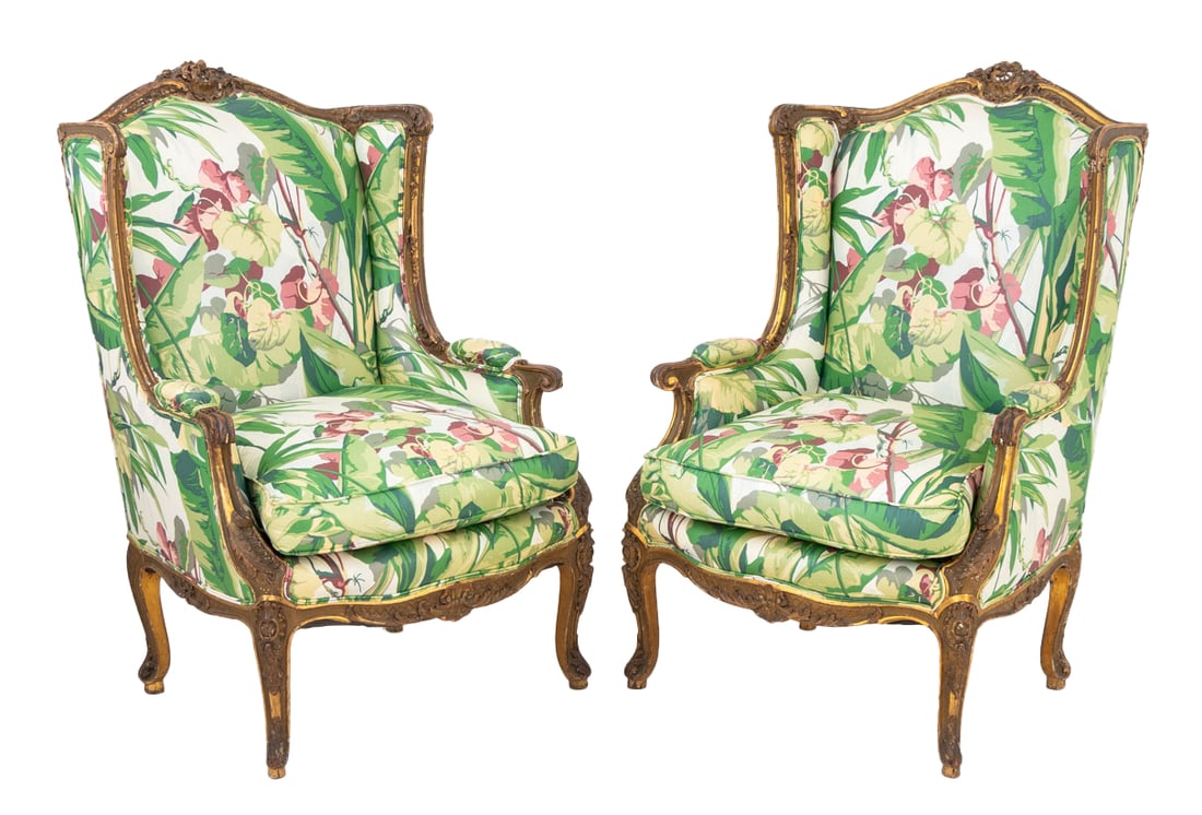 Louis XV Style Giltwood Bergere, Pair: Pair of Louis XV Style Giltwood Bergeres, with floral crest and floral upholstered back and cushion on four carved floral cabriole legs. 46" H x 30" W x 24.5" D; seat: 21" H. Provenance: From an East