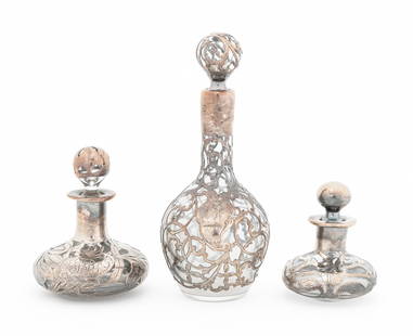 Art Nouveau Silver Overlay Glass Bottles, 3: Set of Three Art Nouveau Silver Overlay Glass Perfume Bottles, early 20th century, one marked "Sterling Silver Deposit 96" to the underside. Silver tested and not weighable. Larger: 6.25" H x 3" Diame