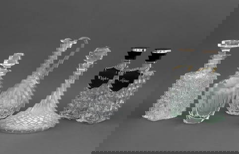 Colorless Cut Crystal Barware, 6 Pcs.: Group of Six Colorless Cut Crystal Barware Pieces, comprising: five decanters, one with crest to center, two with leather labels and one pitcher, all apparently unmarked. Largest: 11" H x 5.5" Diamete