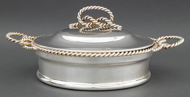 Bonwit Teller Silver Plate Covered Serving Dish: Bonwit Teller Silver Plate Covered Serving Dish, with braided rope motif trim and handles, marked "Made in Italy / Bonwit Teller" to underside, with glass insert. 6.75" H x 15" W x 11" D. Provenance: