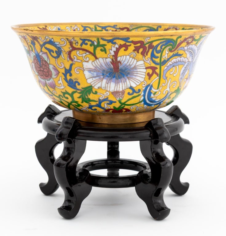 Chinese Cloisonne Enamel Bowl: Chinese Cloisonne Enamel Bowl, with scrolling floral motif on a yellow ground, together with wood stand. Bowl: 4" H x 9" Diameter. Provenance: From the Collection of a New York City Musician. Keywords