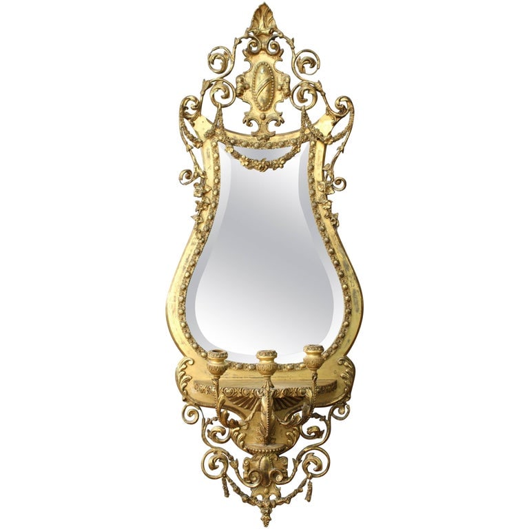 George III Giltwood Girandole Beveled Mirror: George III Giltwood Girandole Beveled Glass Mirror, the ornately carved foliate lyre-shaped frame with gilt swags encasing an antique mirror with original patina, the base section with three candelabr