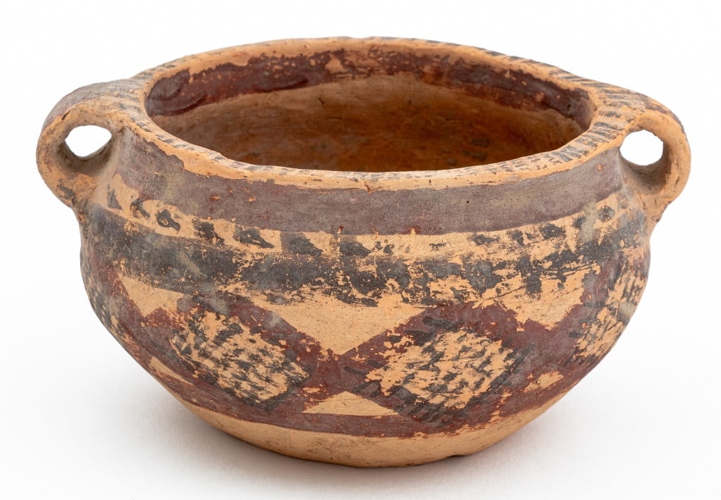 Chinese Neolithic Period Pottery Bowl: Chinese Neolithic Period Pottery Bowl, hand-painted with black and red geometric border and with two molded handles. 3" H x 5.5" W x 4.5" D. Provenance: From a 35 East 75th Street Estate. Keywords: An
