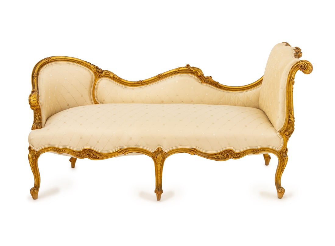 Louis XV Style Giltwood Chaise Longue, 19th C.: Louis XV Style Giltwood Chaise Longue, late 19th century, with beige silk upholstery on six carved cabriole legs. 28.5" H x 57" W x 25.5" D; seat: 16" H. Provenance: From an 880 Fifth Avenue Collectio