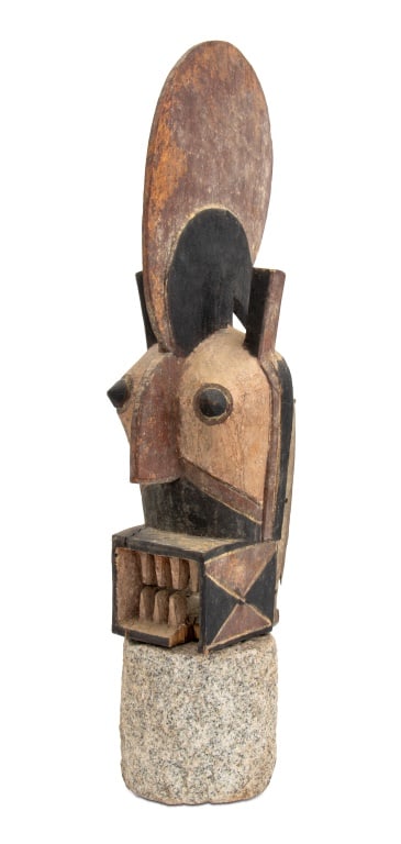 Burkina Faso Bwa Carved and Painted Wood Mask: Burkina Faso Bwa Carved and Polychrome Painted Wood Mask, with bared teeth and head crest, mounted on stone column. 26.75" H x 5.75" W x 9.5" D; overall: 30 H. Provenance: From a New York City Collect