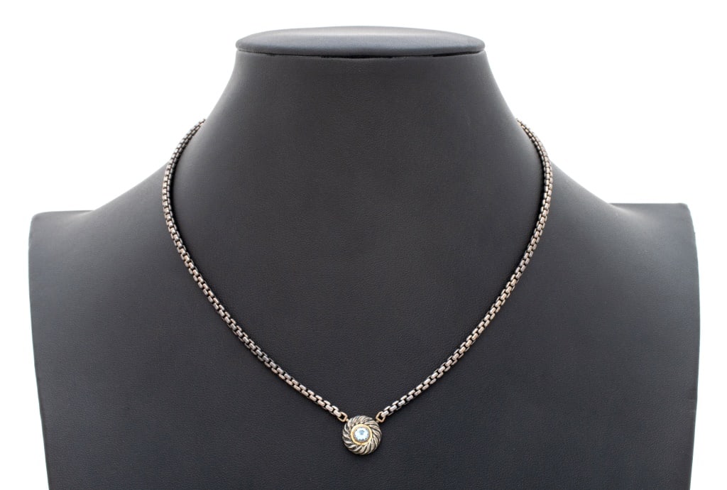 David Yurman Silver 14K Gold Blue Topaz Necklace: David Yurman Sterling Silver 14K Gold Blue Topaz Necklace, chain and attached pendant, antique finished, featuring a round brilliant blue topaz, bezel set in 14K yellow gold, weighing approx. 0.35 car