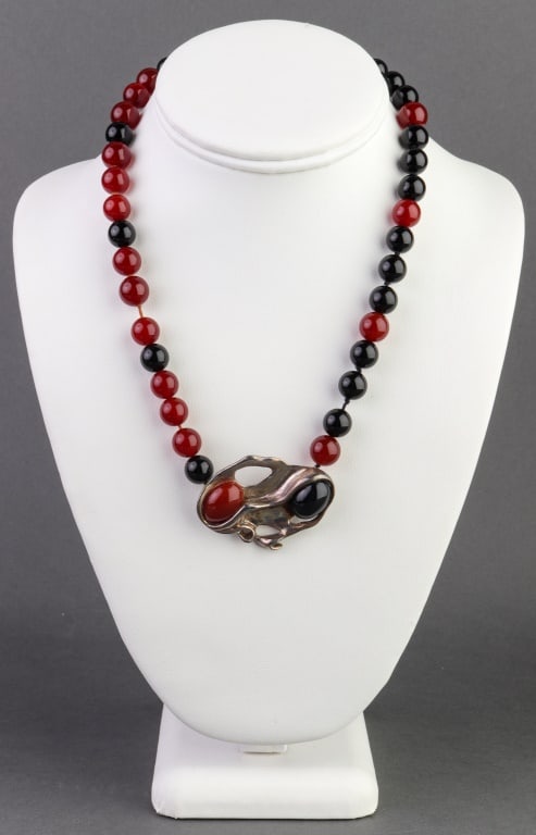 Rita Abrams Silver, Carnelian & Onyx Necklace: Rita Abrams Sterling Silver, Carnelian, and Onyx Necklace, marked "Rita Abrams / STERLING / 925." Necklace measures 18.5" L x 1.375" W (at widest section). Oval carnelian and onyx approx: 16 x 12 mm.
