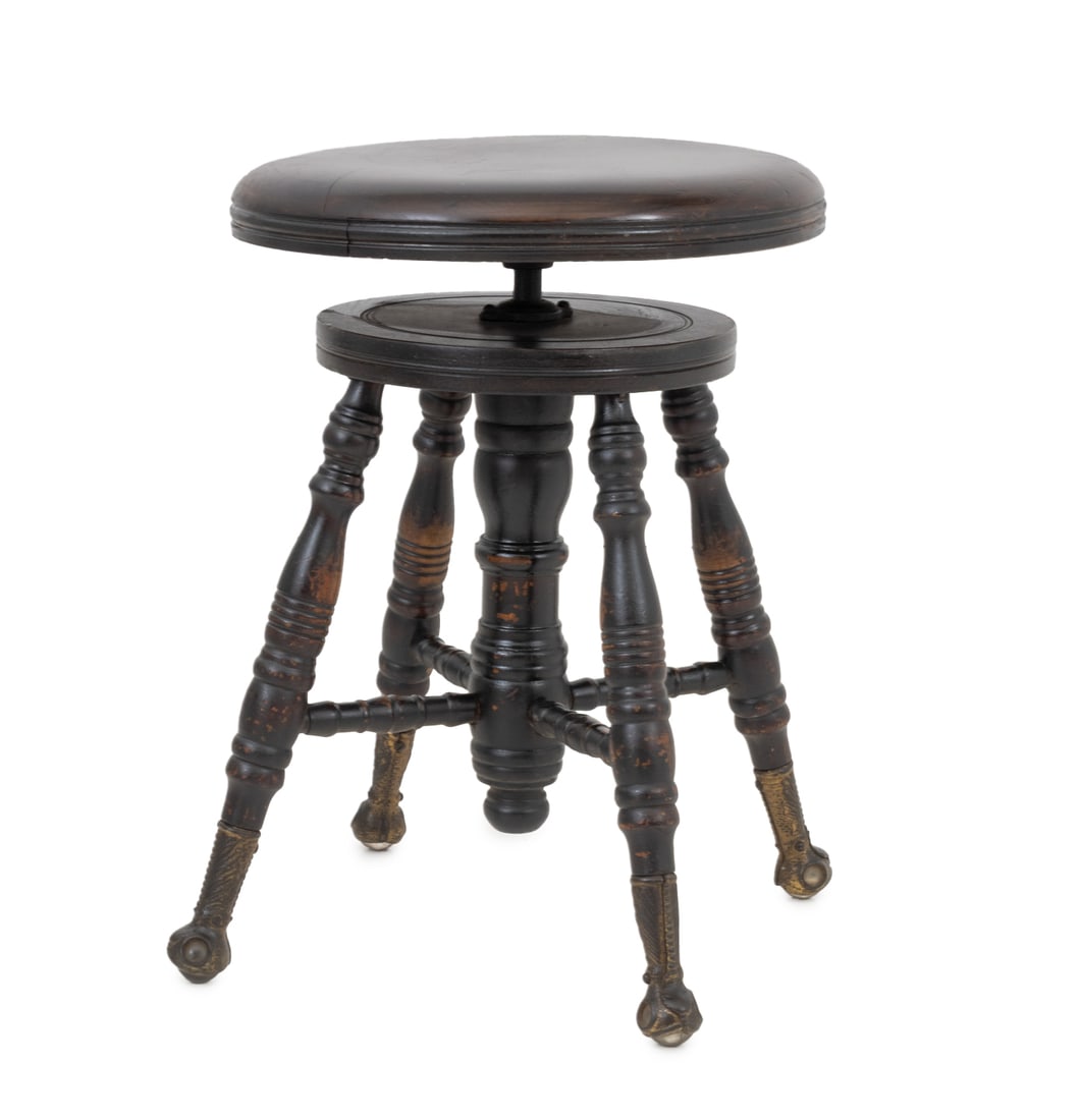 Chas. Parker Co. Mahogany Adjustable Piano Stool: The Chas. Parker Co. Mahogany Adjustable Piano Stool, the circular swivel top above four turned wood tapered legs conjoined by X-form stretcher on brass claw and ball feet, marked " The Chas. Parker C
