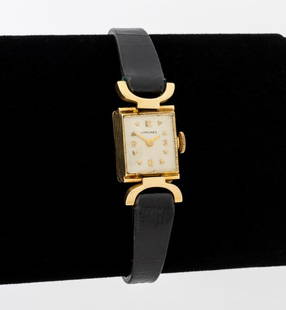 Longines 14K Yellow Gold Watch: Longines 14K Yellow Gold Wristwatch, with silvered dial, golden Arabic numeral and arrow indexes, powered by manual wind-up movement, worn on wrist with black leather strap and buckle clasp, marked: "