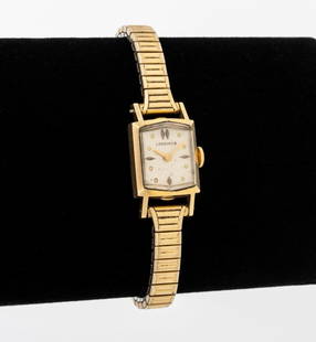 Longines 14K Yellow Gold Wristwatch: Longines 14K Yellow Gold Wristwatch, with silvered dial, golden dot and dagger indexes, powered by manual wind-up movement, worn on wrist with speidel strech band with gold fill caps, marked: "Longine