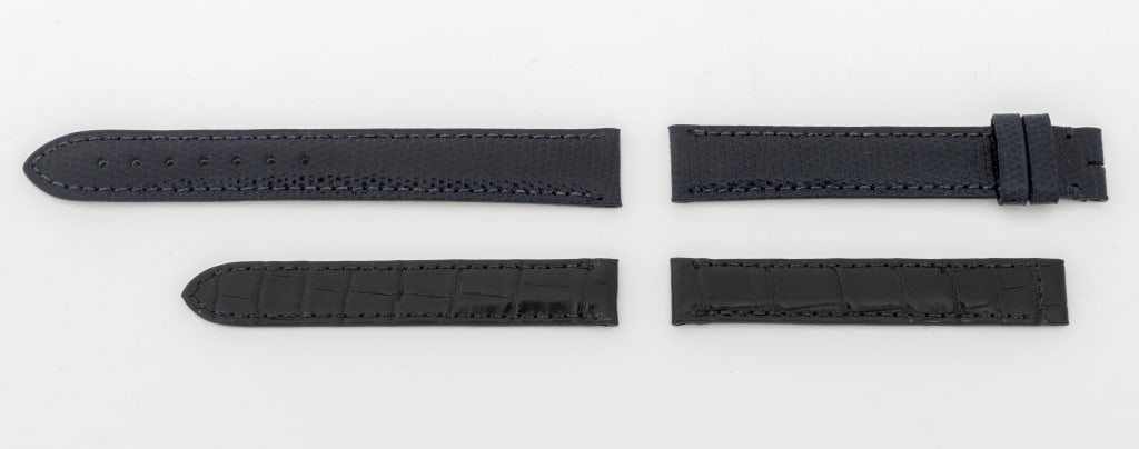 Cartier Watch Straps, 2 Pcs.: Two Cartier Watch Straps, comprising: black alligator for deployment buckle, marked "Cartier" and navy blue lizard, marked "1AQDAA08 / Cartier". Larger: 15mm x 117mm. Provenance: From a Manhattan Coll