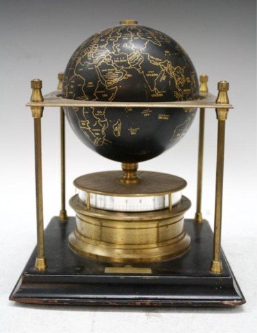 A Royal Geographical Society World Clock: A gilt metal square frame supporting a terrestrial globe marked in gilt in a black ground, raised on a drum movement with annular 24-hour dial, 1988, England, marked. Dimensions: 11"H x 9"L x 9"W
