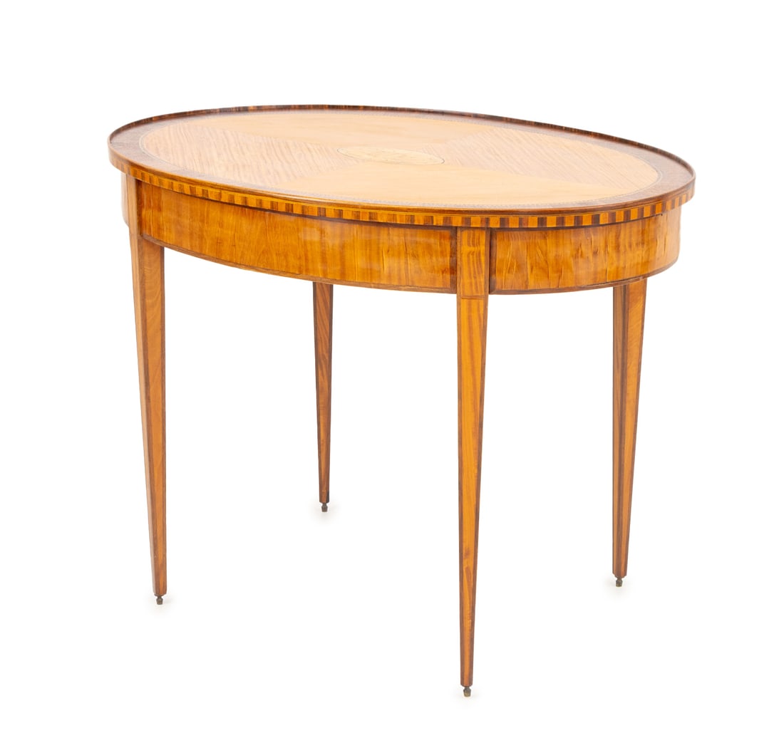 George III Oval Satinwood Occasional Table: George III Oval Satinwood Marquetry Occasional Table, with inlaid shell motif to the center of top on four tapered legs. 29.75" H x 39.5" W x 24" D. Provenance: Property from a Bunny Williams decorate