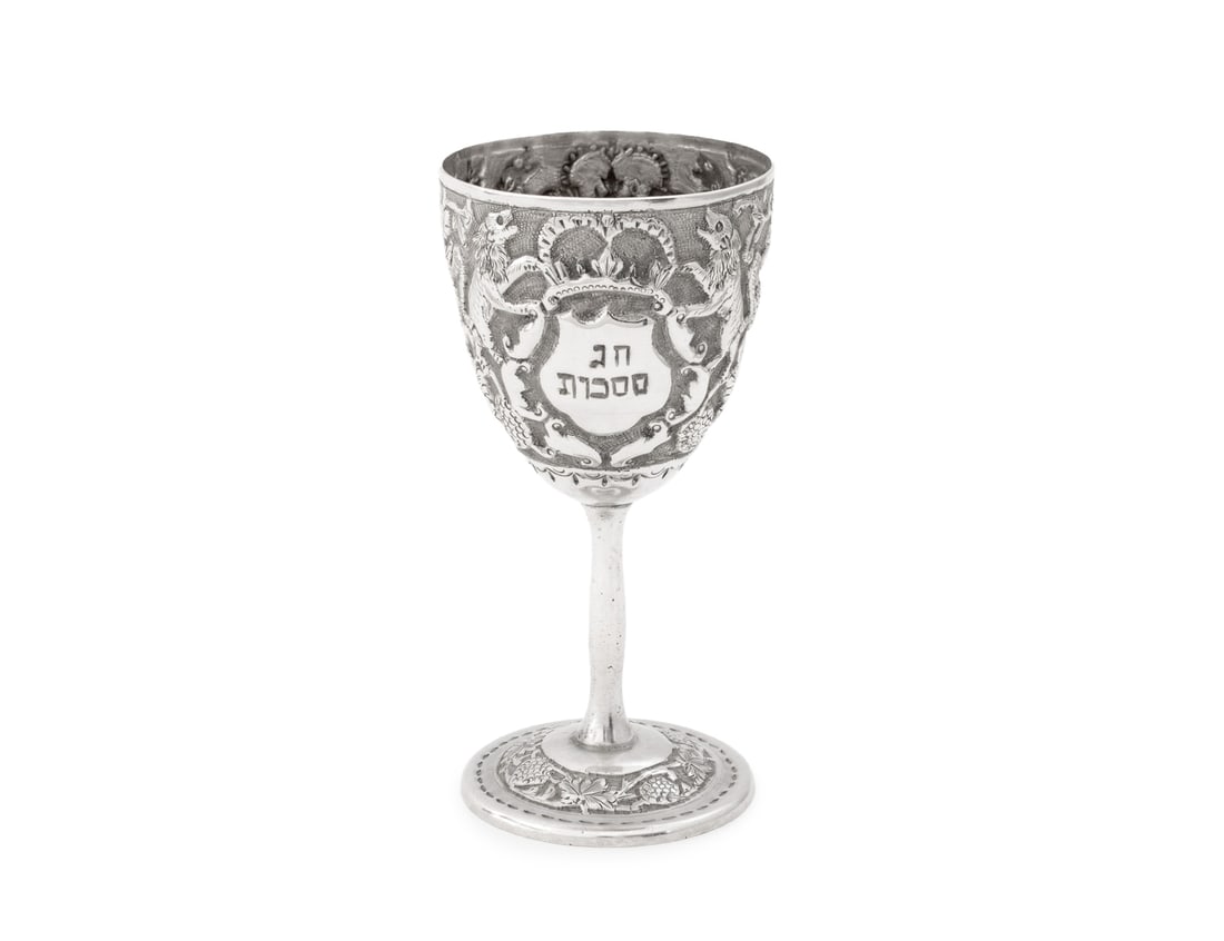 Judaica Silver Kiddush Cup, 19th C.: Judaica Silver Kiddush Cup, 19th century, with repousse grapevine motif and two crests flanked by roaring lions, one crest with Hebrew wine prayer and the other in Hebrew "Chag Sukkot" for the The Fea