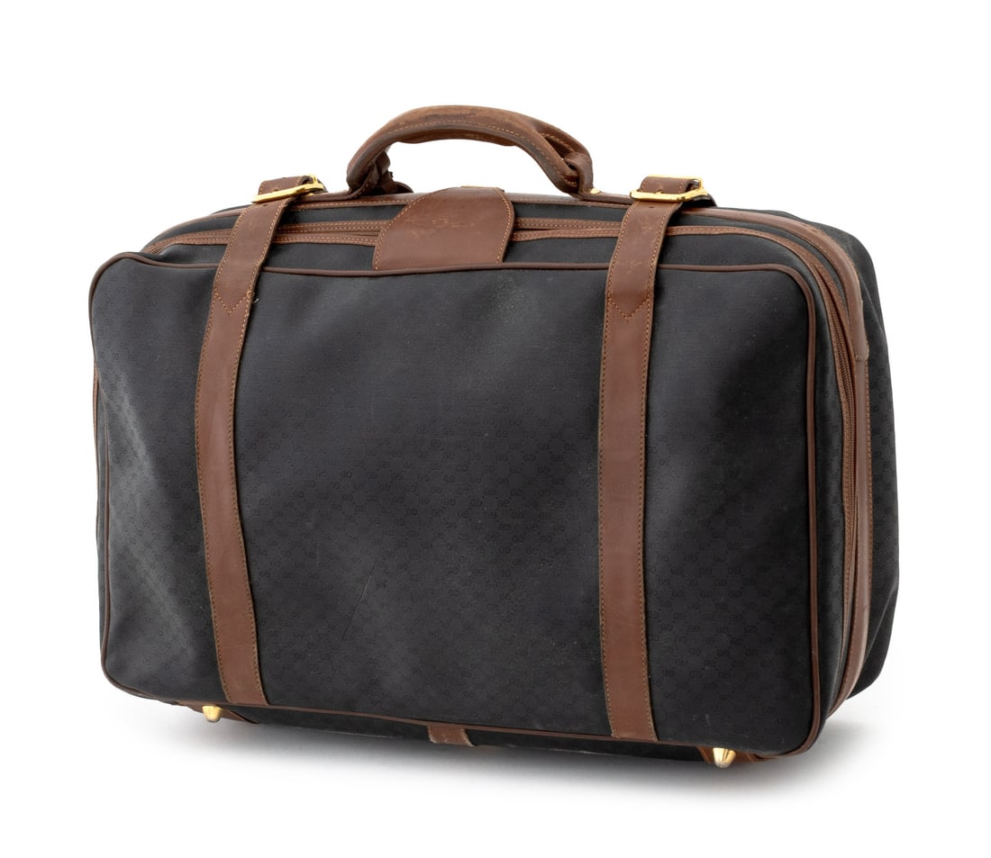 Gucci Monogrammed Black Canvas & Leather Suitcase: Gucci Monogrammed Black Canvas and Brown Leather Suitcase, with top handle and double buckle strap, the single zipper opening to black leather lining with white cotton double straps, marked "Gucci / M