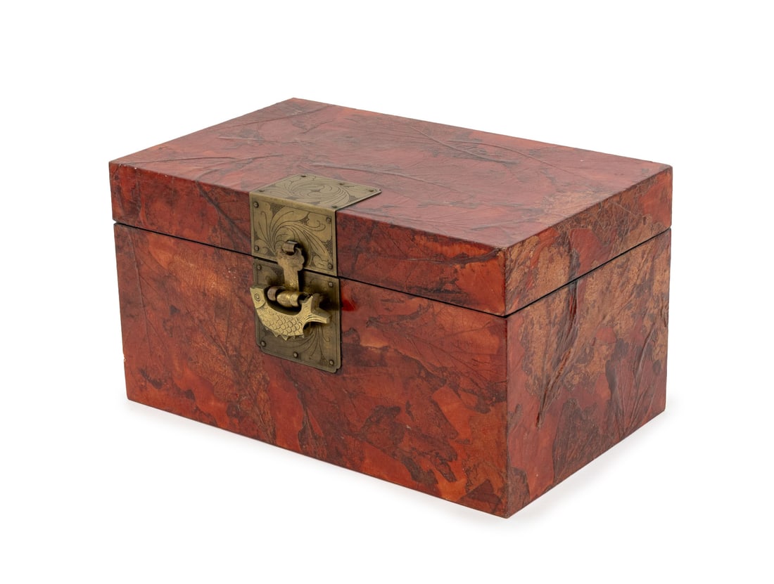 Chinese Red Lacquered Leaf Covered Box: Chinese Red Lacquered Tobacco Leaf Covered Box, with brass fish form lock and key, the hinged top opening to paper-lined interior with fitted tray. 8.25" H x 15.25" W x 10" D. Provenance: From the