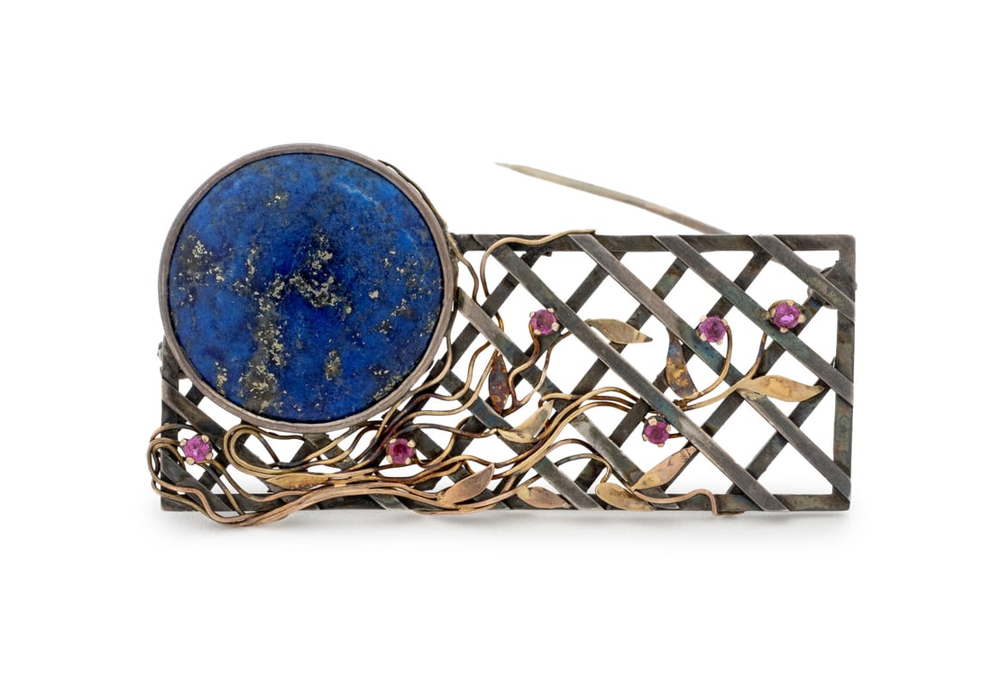 Sterling Silver 14K Yellow Gold Lapis Ruby Brooch: Sterling Silver and 14K Yellow Gold Lapis Ruby Brooch, featuring one bezel set round lapis cabochon weighing approx. 19.60 carats, further adorned with six prong set round faceted rubies weighing a