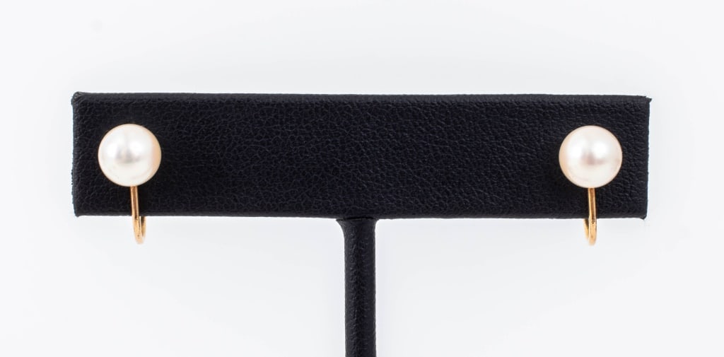 14K Yellow Gold Pearl Stud Earrings: Pair of 14K Yellow Gold Pearl Stud Earrings, featuring two cultured round pearls, approx. 6.8 - 7.0 mm, worn on earlobes with clip on threaded backs and pads, marked: "14K M". Measuring approx. 5/8"