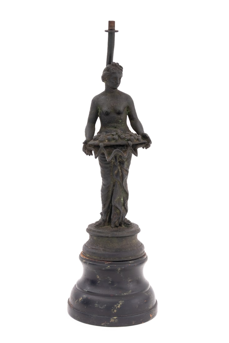 After the Antique Pomona Metal Sculpture Lamp Base: After the Antique Pompeii Pomona Patinated Metal Sculpture Mounted as a Lamp Base, depicting the goddess holding an shell overflowing with gathered fruits, on ebonized wood socle base. Overall: 16.5"