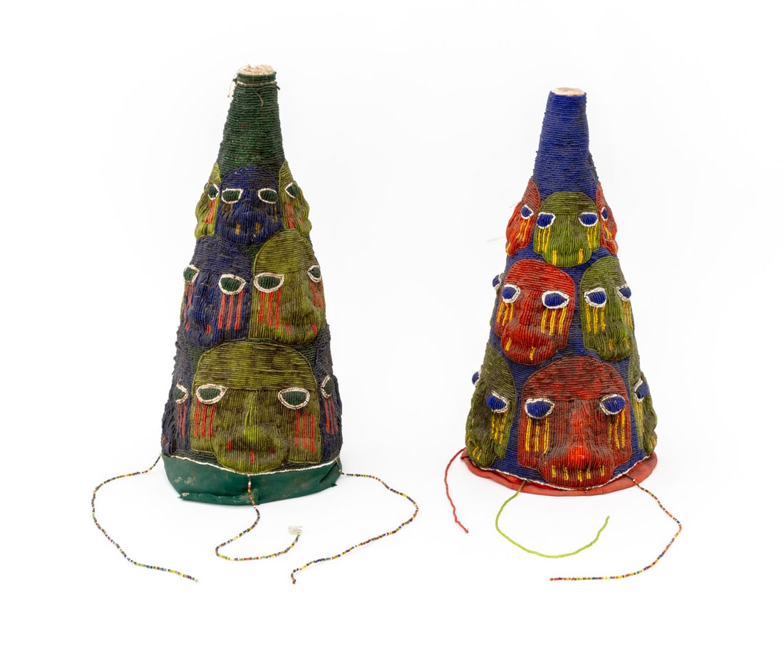 Yoruba Beaded Ceremonial Headdresses, 2: Two Yoruba Beaded Ceremonial Headdresses, each with polychrome abstracted faces. Taller: 17" H x 8.5" Diameter. Provenance: From the Collection of Laura and Lewis Kruger. Keywords: African Art, Beadwo