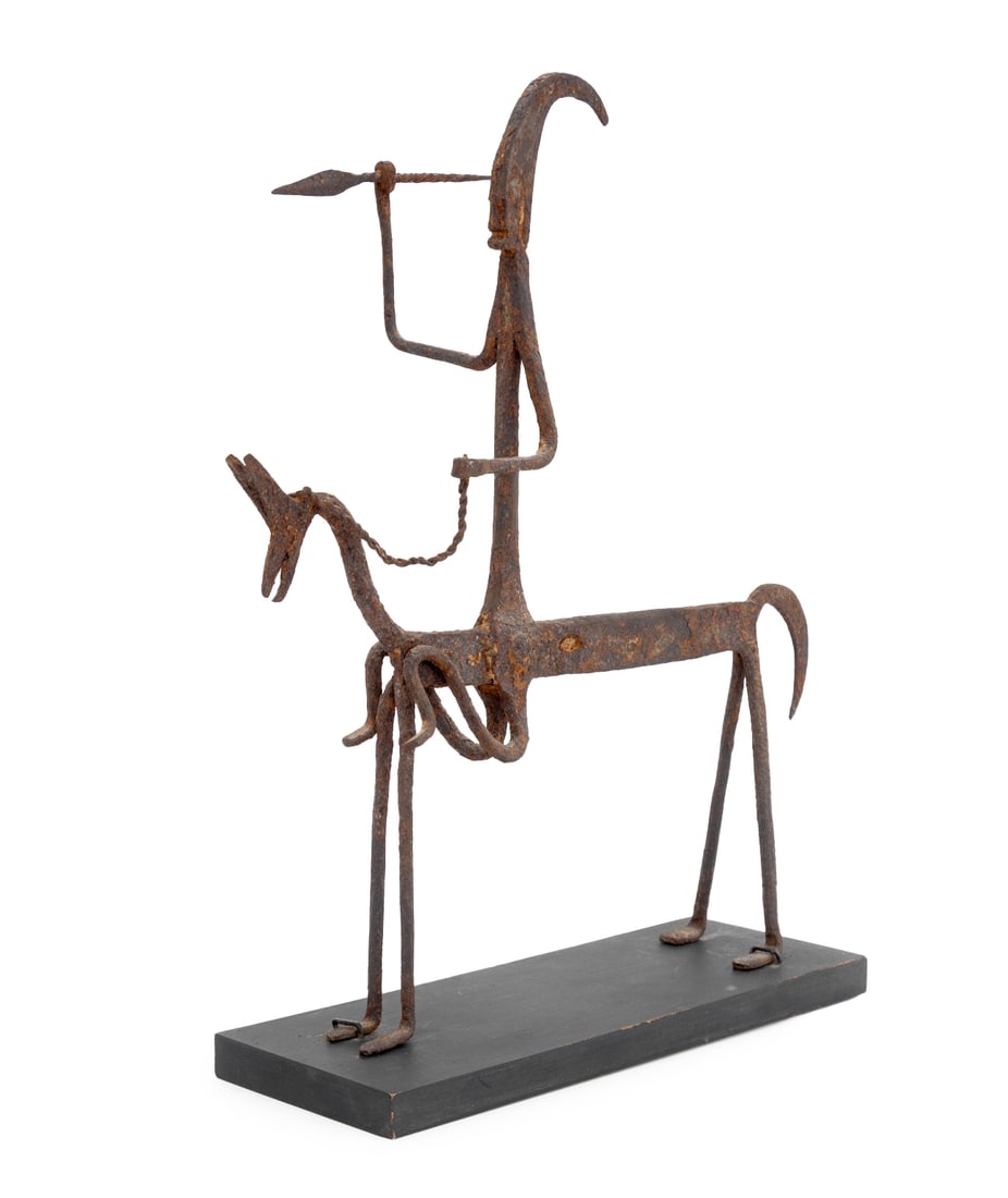 African Dogon Horse & Rider Iron Sculpture: African Dogon Horse and Rider Iron Scupture, the warrior wielding a spear, atop an ebonized wood base. Overall: 15.5" H x 12" W x 4.25" D. Provenance: From the Estate of American Fashion Journalist an