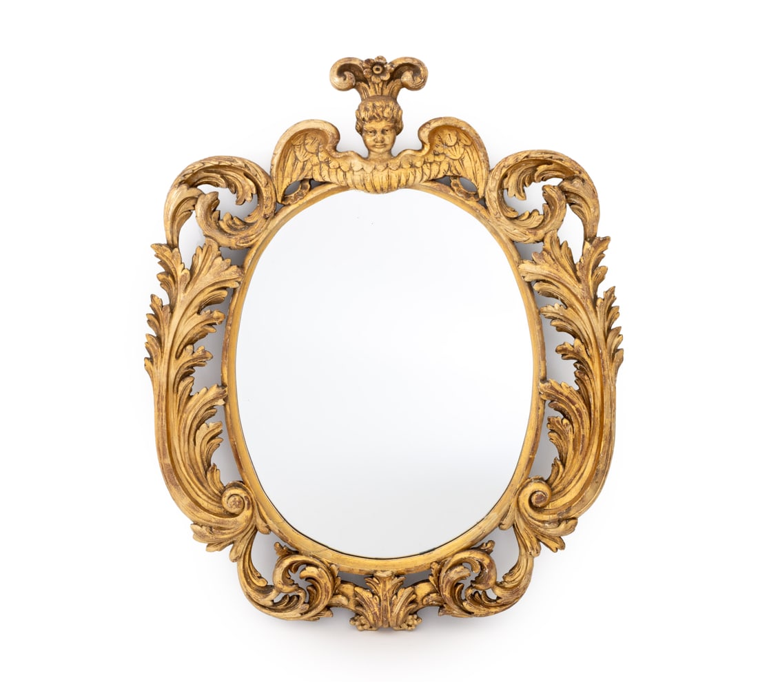 Baroque Style Carved Giltwood Mirror: Baroque Style Carved Giltwood Mirror, with putti crest and oval mirror surround by ornate scroll form and acanthus leaf frame, auction label to reverse. Mirror plate: 23.5" H x 18.5" W; frame: 36.5"