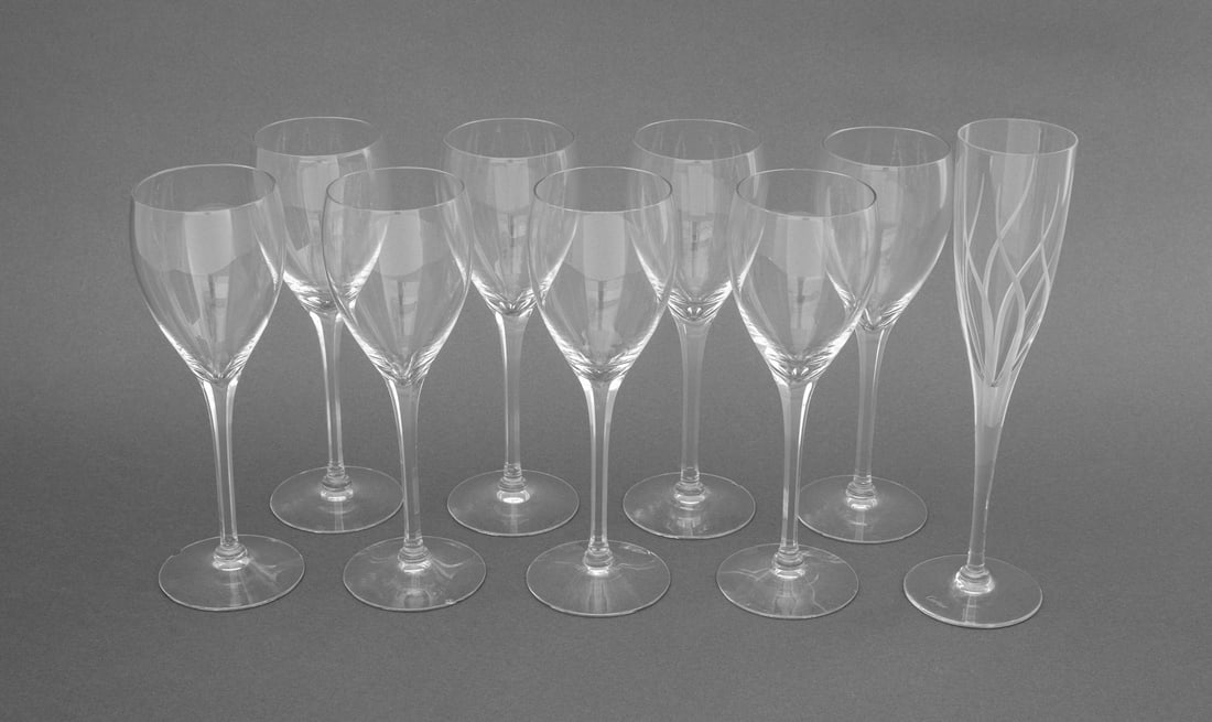 Cartier Crystal Stemware, 9 Pcs.: Group of Nine Cartier Crystal Stemware Pieces, each marked and comprising: one etched champagne flute and eight wine glasses. Tallest: 9.5" H x 2.75" Diameter. Provenance: From the Estate of American