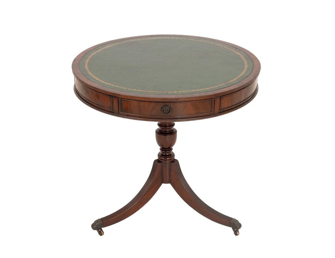 Green Leather Top Mahogany Drum Table: Gilt-Tooled Green Leather Top Mahogany Drum Table, the circular top with three drawers above three legs terminating in lion's paw feet on casters. 30" H x 32" Diameter. Provenance: From the Estate of