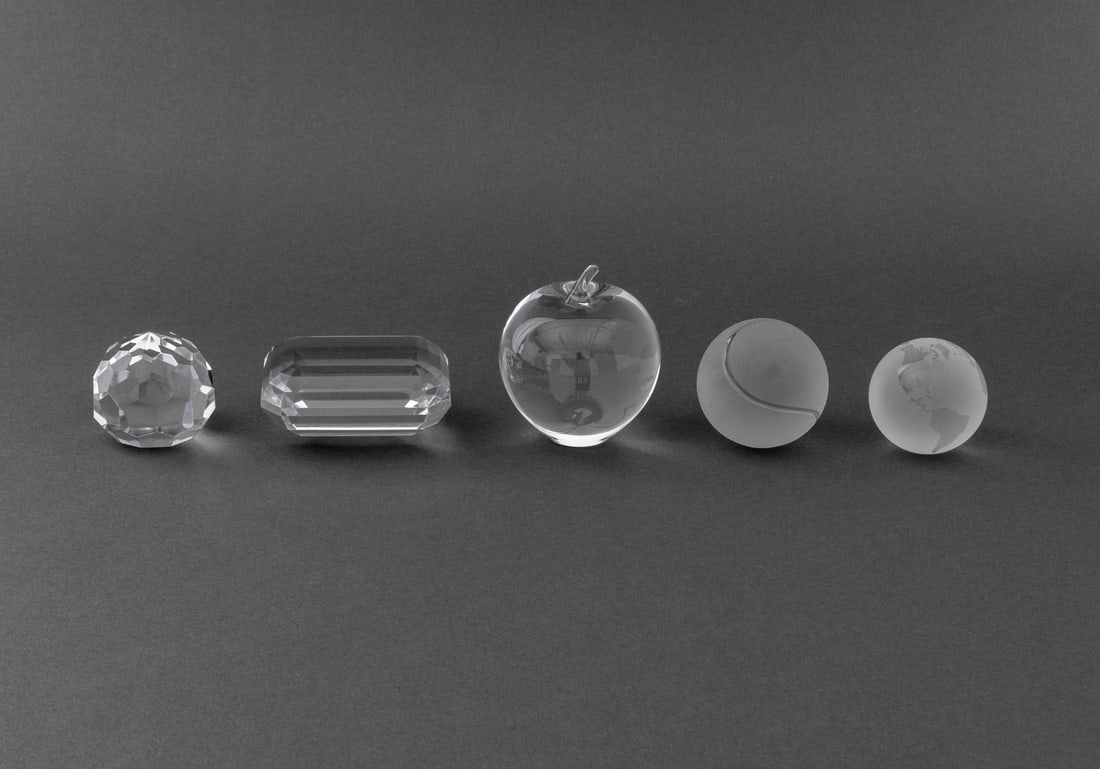 Designer Crystal Paperweights, 5: Group of Five Designer Crystal Paperweights, comprising: Tiffany & Co. apple, engraved "Landmarks of New York / Landmarks Preservation Foundation" to the front, marked, Tiffany & Co. rectangular prism