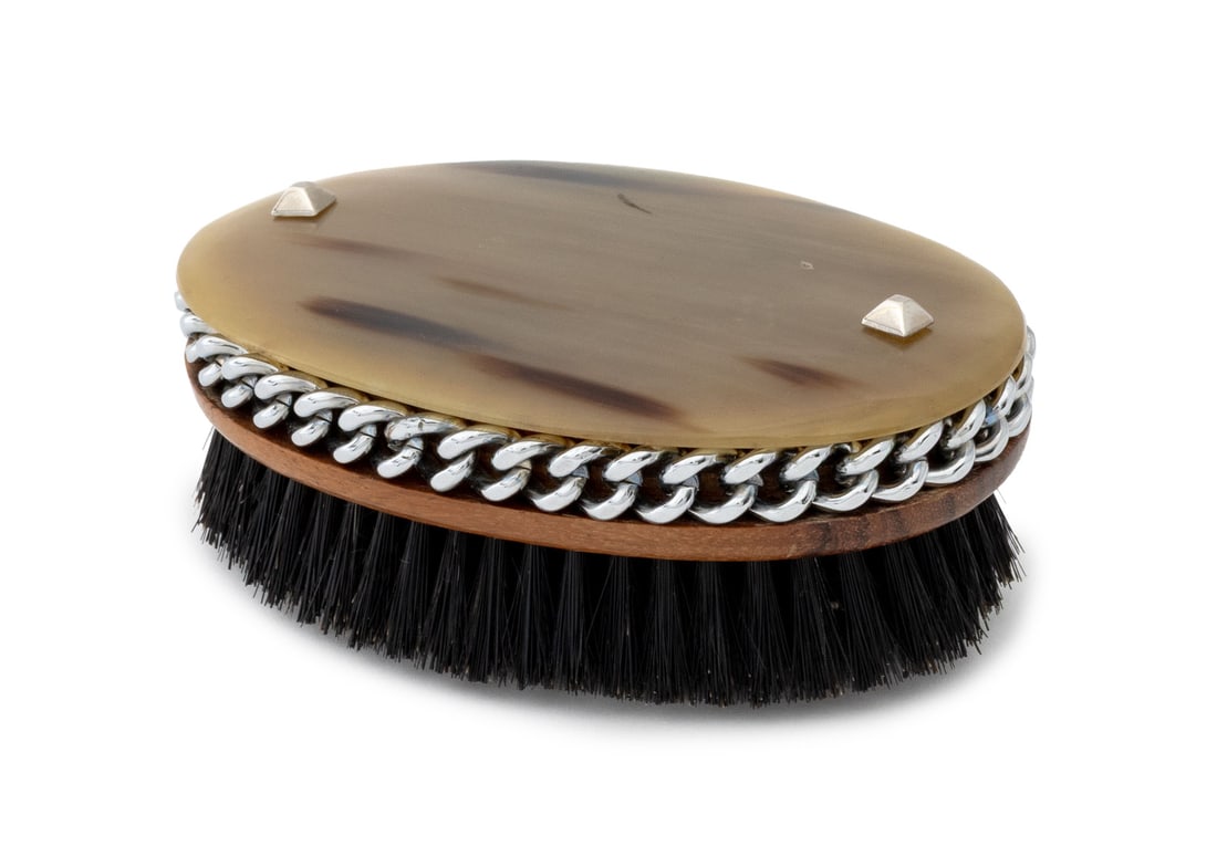 Hermes Style Oval Horn Handle Hair Brush: Hermes Style Oval Horn Handle Hair Brush, with silver-tone chain trim and wood base with brass bristles. 1.75" H x 5.25" W x 3.5" D. Provenance: From the Estate of American Fashion Journalist and Edit