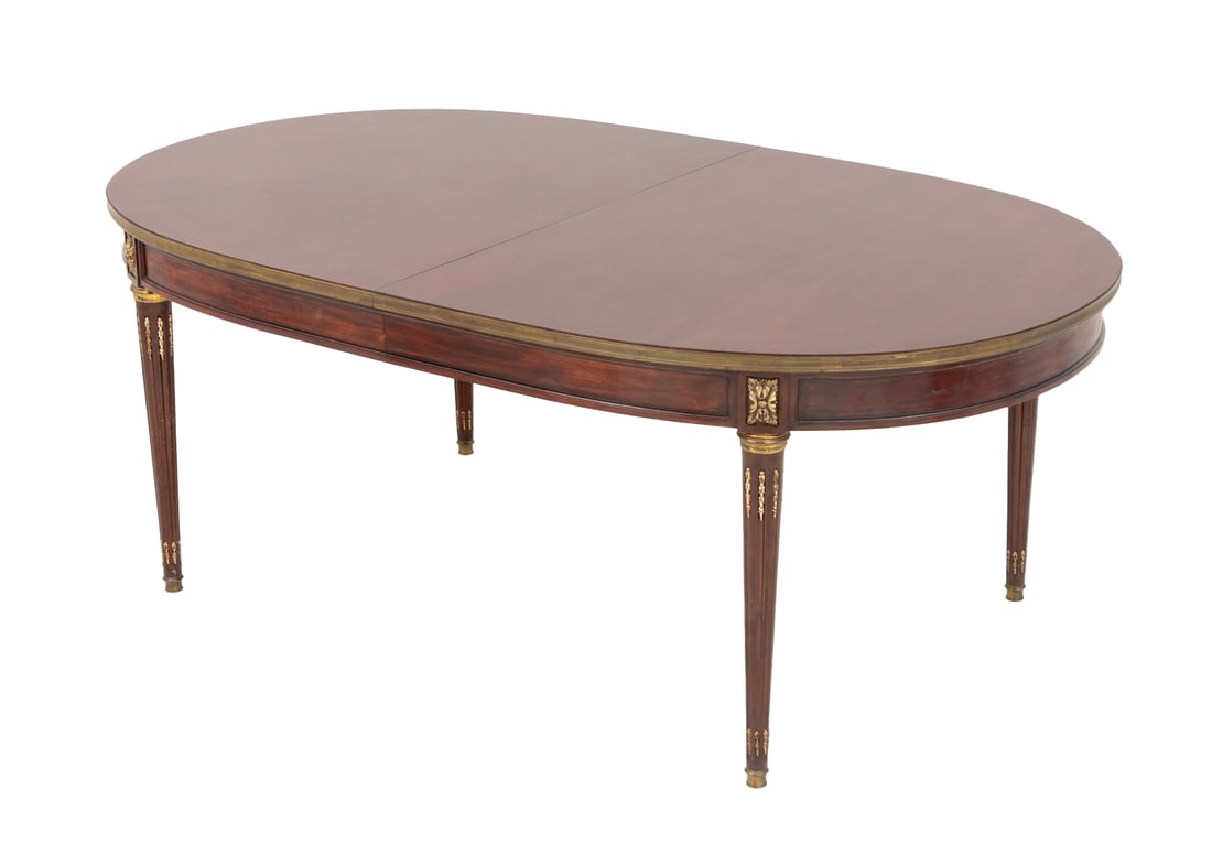 Louis XVI Style Mahogany Extending Dining Table: Louis XVI Style Mahogany Extending Dining Table, with two extension leaves and gilt metal mounts atop four fluted legs. Without leaves: 29.5" H x 74" W x 54" D; each leaf: 20" W. Provenance: From an E