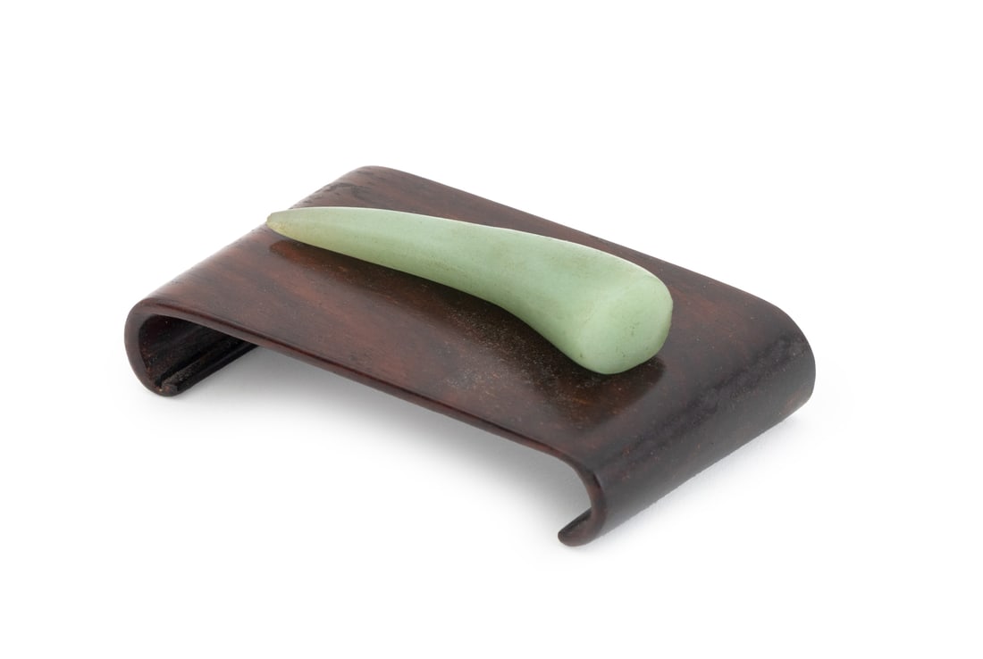 Chinese Jadeite Carving: Chinese Jadeite Carving, of horn form, together with scroll form hardwood stand. Overall: 1.5" H x 3" W x 1.75" D. Provenance: From the Upper East Side Apartment of a Former Ambassador. Keywords: