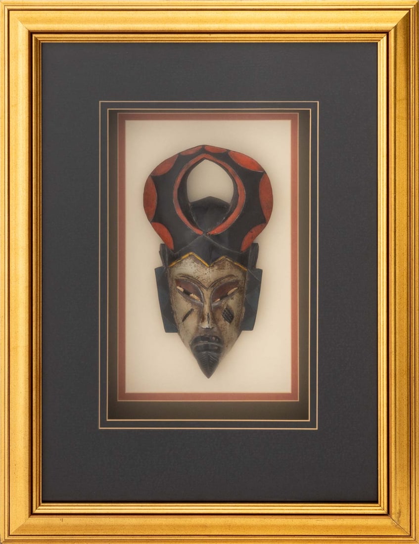 African Baule Polychromed Carved Wood Mask: African Baule Polychrome Painted and Hand-Carved Wood Mask, giltwood frame. Image: 13" H x 6.25" W; frame: 27.5" H x 21.25" W x 4" D. Provenance: From an 880 Fifth Avenue Collection. Keywords: