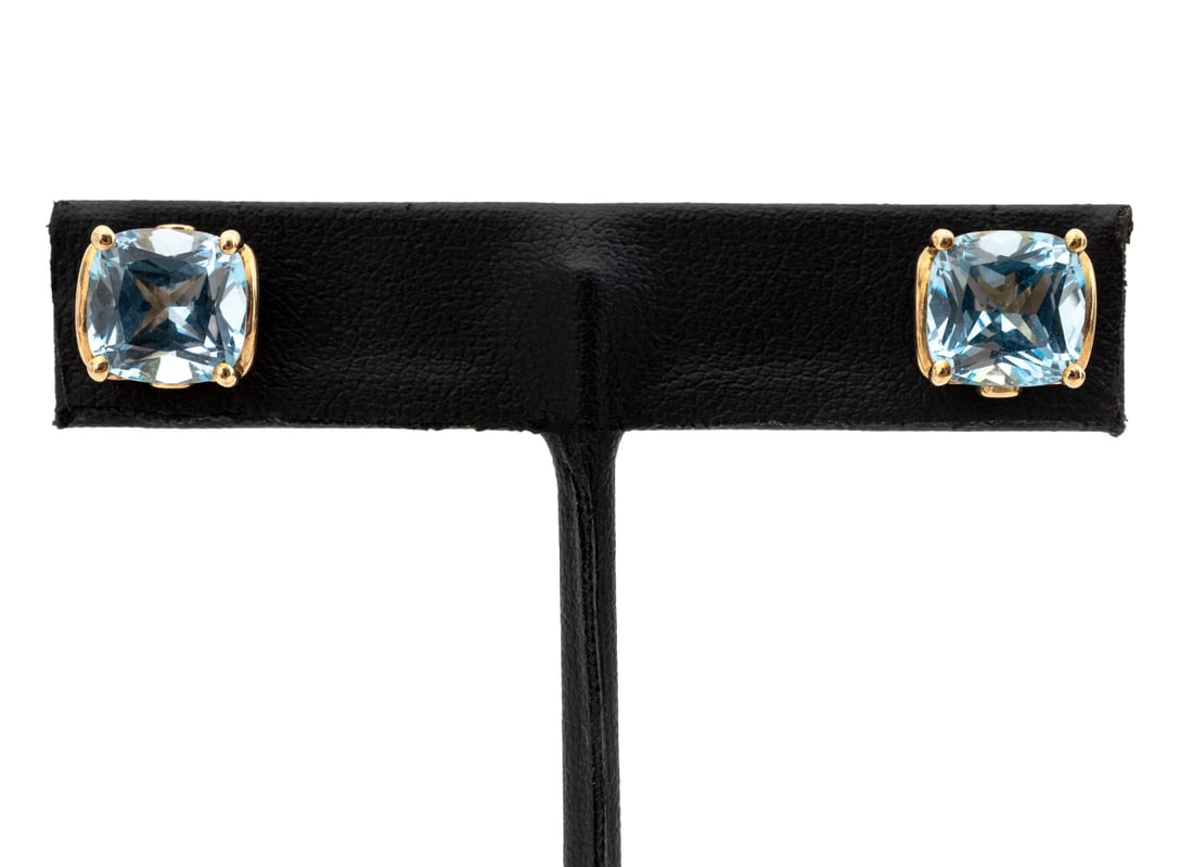 9K Yellow Gold Blue Topaz Earrings: Pair of 9K Yellow Gold Blue Topaz Earrings, featuring two prong set cushion brilliant cut blue topaz weighing a total of approx. 7.00 carats, further decorated with four bezel set round faceted blue