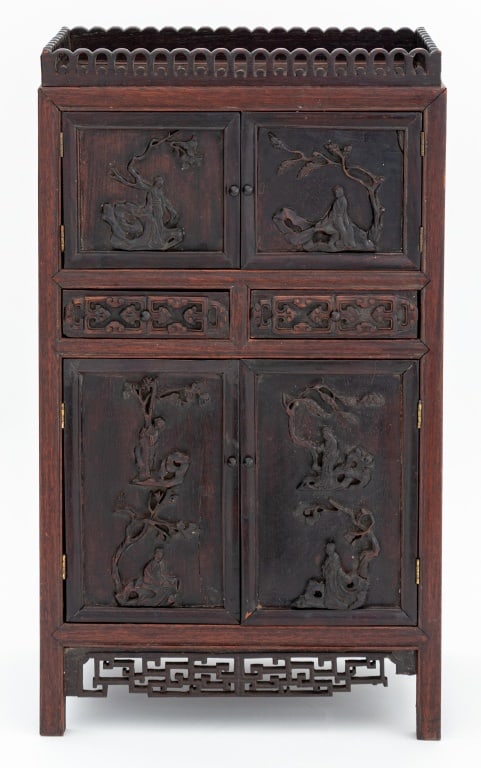Chinese Hardwood Table Cabinet: Chinese Hardwood Table Cabinet, early 20th century, pierced pediment above an arrangement of carved doors, divided by carved drawers, fretwork panels on block feet. 22" H x 12.5" W x 7" D. Keywords: A