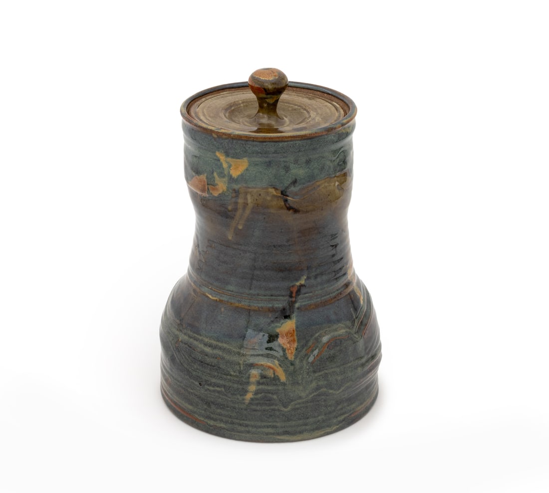 John Glick Polychrome Glazed Pottery Covered Jar: John Glick (American, 1938-2017) Blue and Tan Glazed Art Pottery Covered Jar, with ribbed details, signed and stamped "Plum Tree Pottery" to underside. 14" H x 9.5" Diameter. Provenance: From a