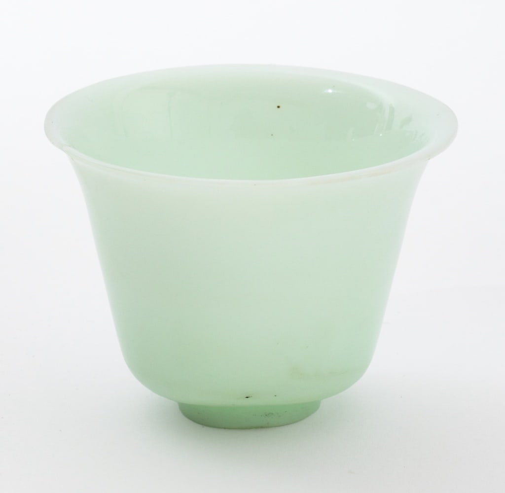 Chinese Celadon Jade Wine Cup: Chinese Carved Celadon Jade Wine Cup, raised on a circular foot. 2.5" H x 3.5" Diameter. Provenance: From an East 72nd Street Estate. Keywords: Asian Art, China, Carving, Carved stone, Hardstone,