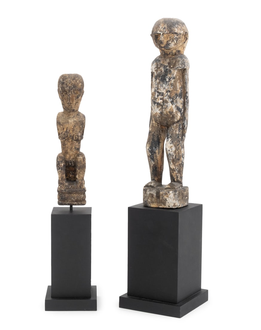 African Hand-Carved Wood Sculptures, 2: Two African Hand-Carved Wood Sculptures, probably Lobi, each raised atop a black pedestal stand. Larger overall: 20.5" H x 4.75" W x 4.75" D. Provenance: From an East 53rd Street Collection. Keywords: