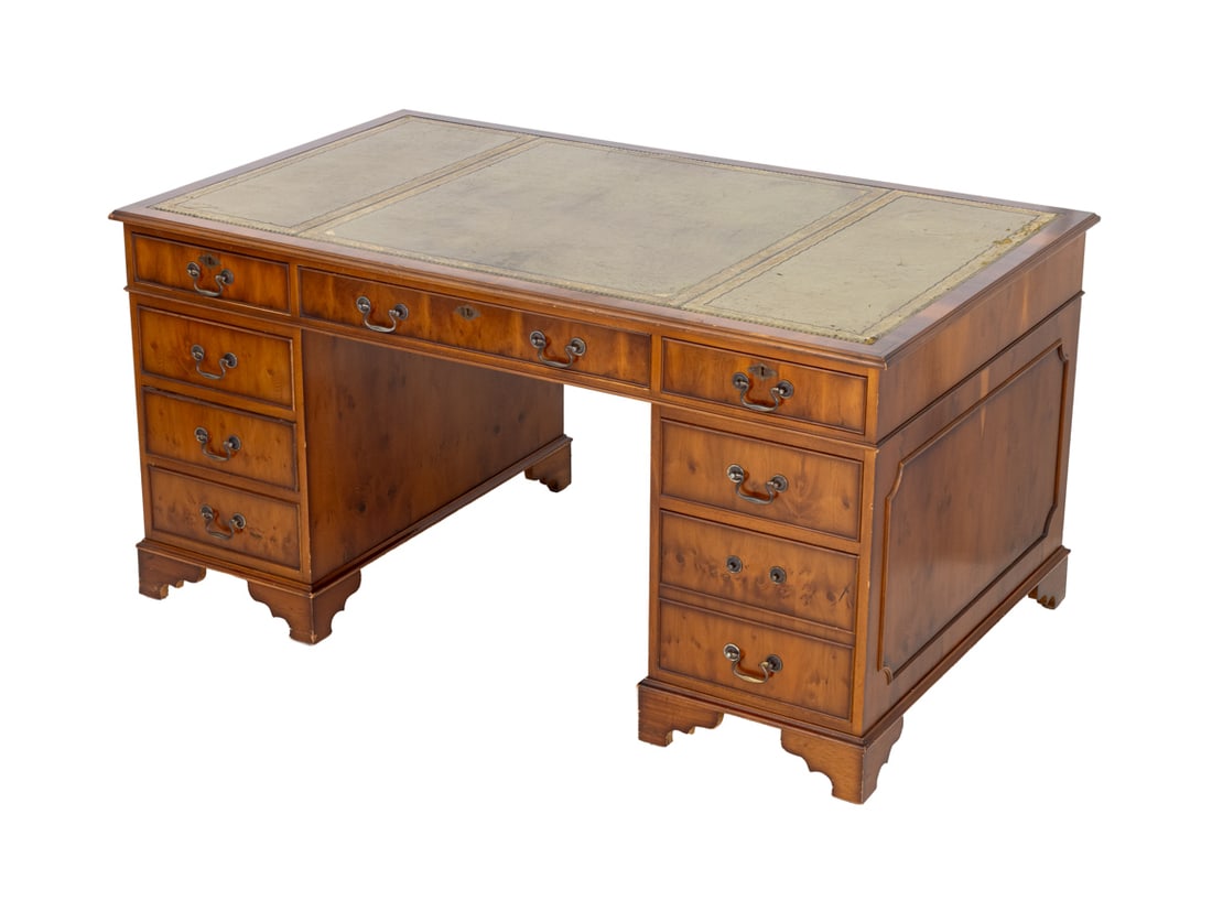 George III Style Yew Pedestal Desk: George III Style Yew Wood Pedestal Desk, with gilt-tooled green leather top above central long drawer flanked by eight drawers. 30.5" H x 59.75" W x 36" D. Provenance: From an East 63rd Street, New