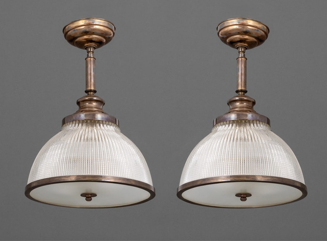 Industrial Brass & Ribbed Glass Chandeliers, Pair: Pair of Industrial Brass and Ribbed Glass Chandeliers, the domed glass shade with brass trim. 18.5" H x 13" Diameter. Provenance: Property from a Bunny Williams decorated 5th Avenue Estate. Keywords: