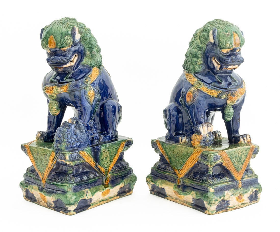 Chinese Three-Color Glazed Buddhist Lions, Pair: Pair of Chinese Polychrome Glazed Ceramic Buddhist Lion Sculptures, with amber yellow, spinach green, and cobalt blue glazes. Each: 18" H x 9" W x 7.5" D. Provenance: From the Upper West Side Estate o