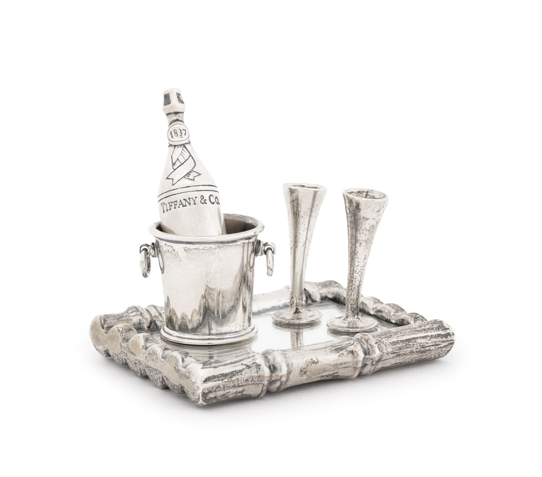 Tiffany & Co. Miniature Sterling Champagne Set: Tiffany and Company Sterling Silver Champagne Set, all marked "925" and comprising: pair of diminutive champagne flutes, champagne bucket and nine base metal ice cubes, 1837 champagne bottle, and bamb