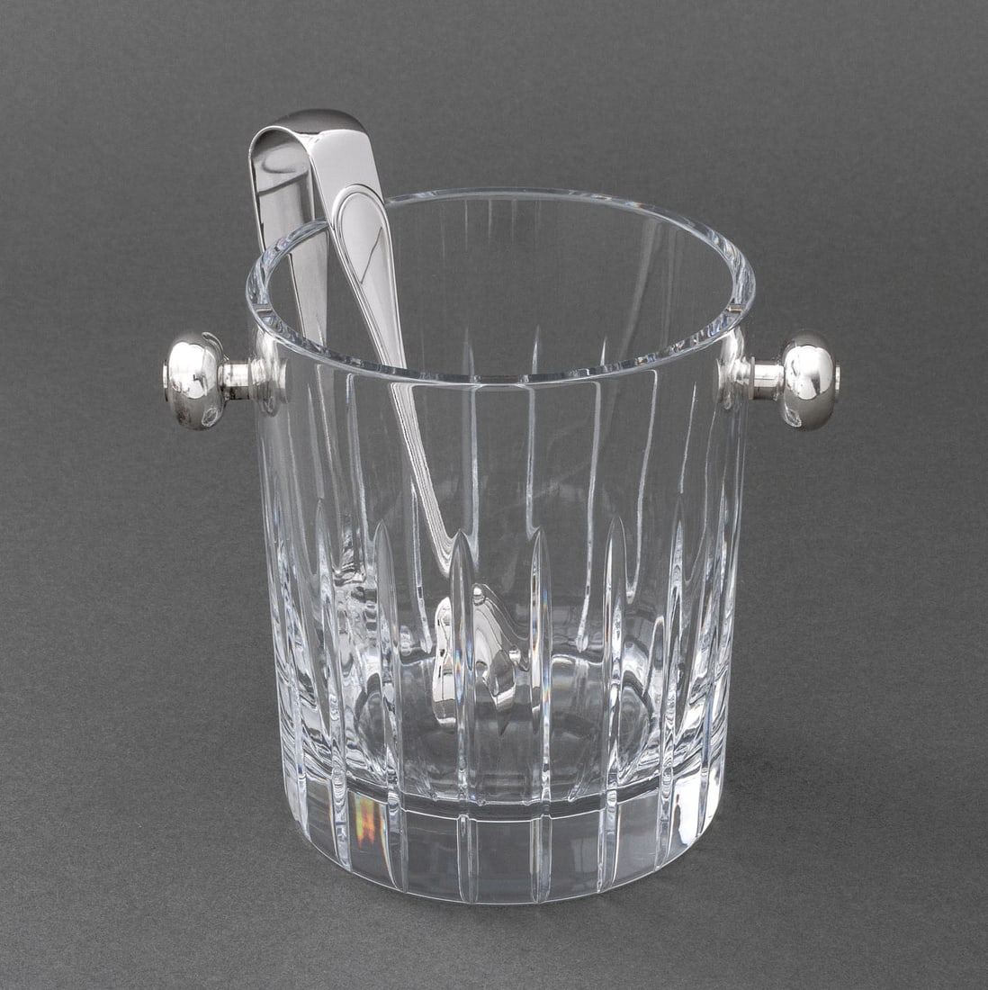 Christofle Crystal and Silver Plate Ice Bucket: Christofle Crystal and Silver Plate Ice Bucket, with ball form handles, with set of "Olri" tongs, marked "Christofle" to underside. 5.5" H x 6.25" W x 4.75" D. Provenance: From a 955 Fifth Avenue