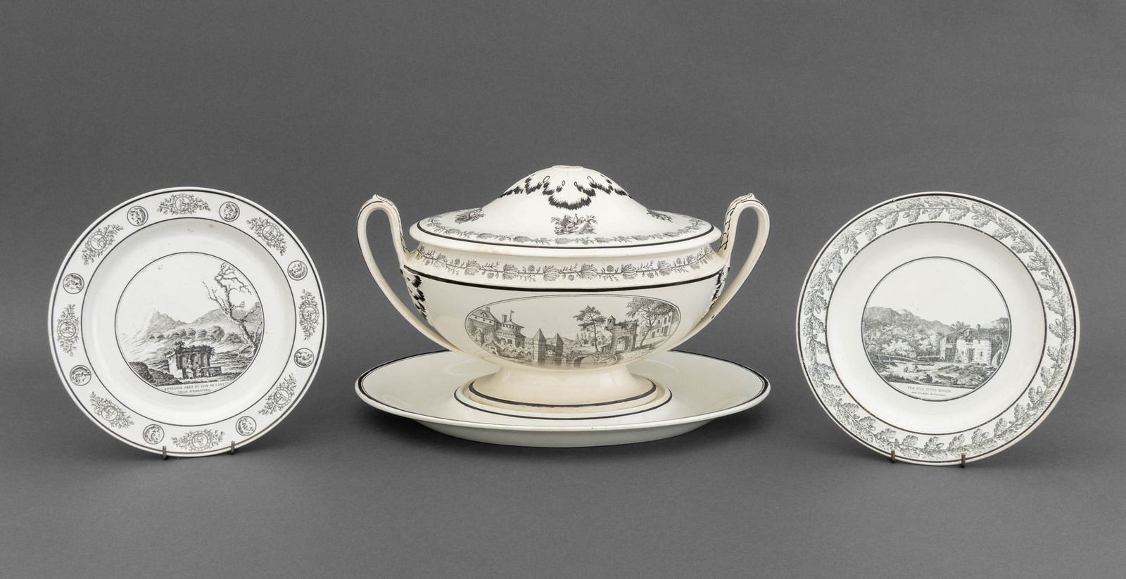 French Creamware Tableware, 3 Pcs.: Group of Three French Creamware Tableware Pieces, comprising: covered tureen two-handled tureen, with black transfer village scenes, foliate trims, and underplate and (2) two plates with transferware
