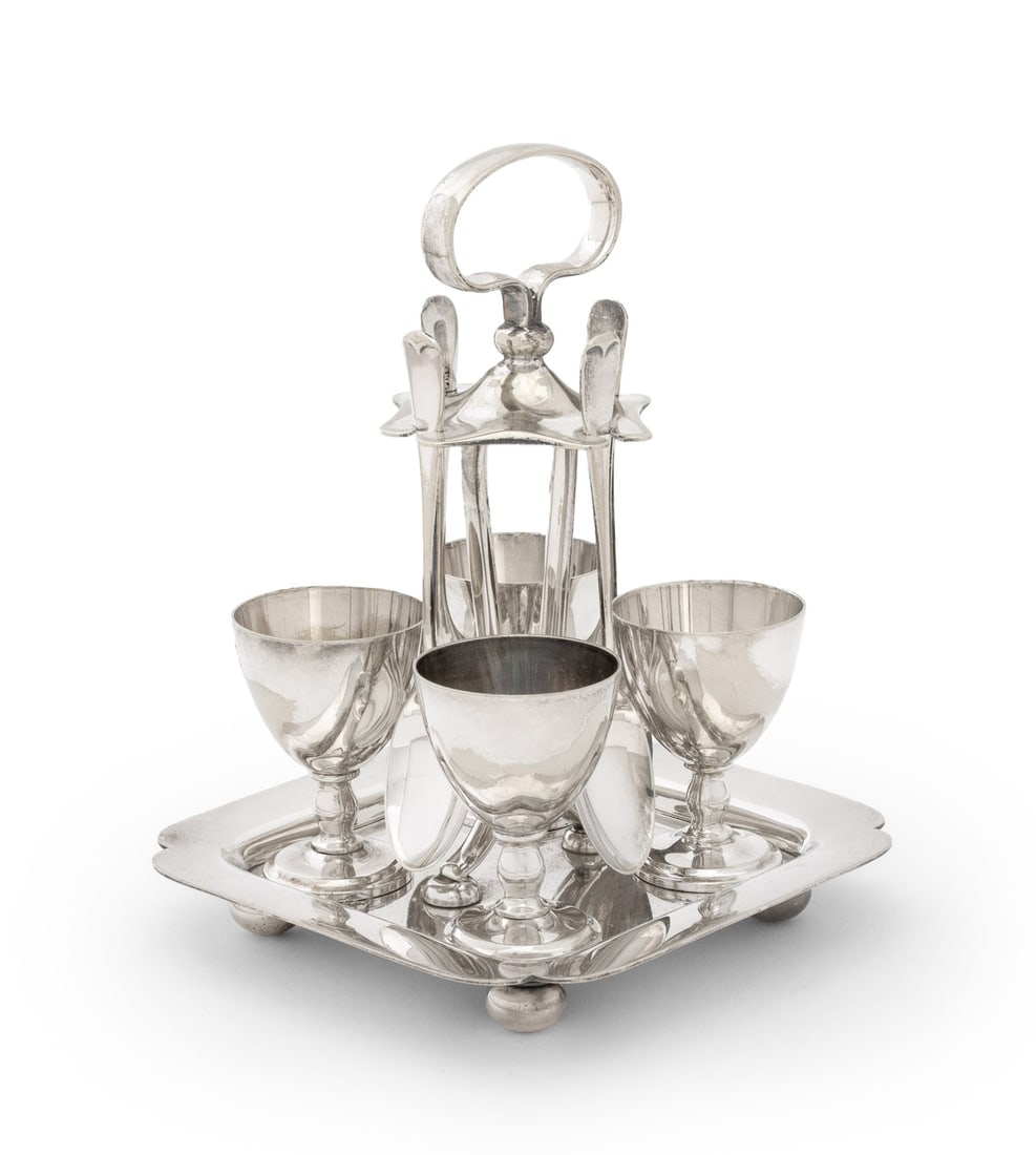 Christofle Silver Plate Egg Cup Set, 9 Pcs.: Christofle Silver Plate Egg Cup Set, comprising: (4) four cups, (4) four spoons, and (1) one stand on four ball feet, marked to underside. 6.75" H x 5" W x 5" D. Provenance: From an East 53rd Street