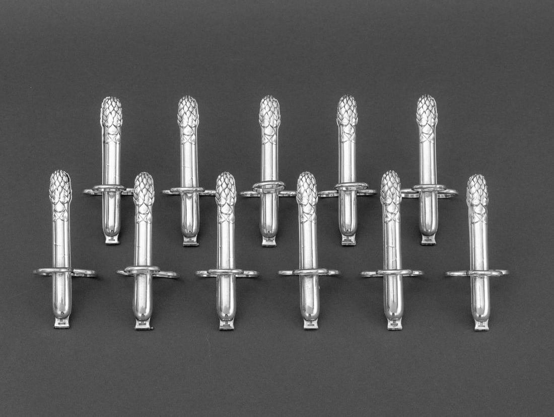 Christofle Silver Plate Asparagus Tongs, 11: Set of 11 Christofle Silver Plate Asparagus Tongs, marked to the hinge. 2.5" H x 1.75" W x 5" D. Provenance: From a New York City Collection. Keywords: Service, Utensils, Tableware, Dining,
