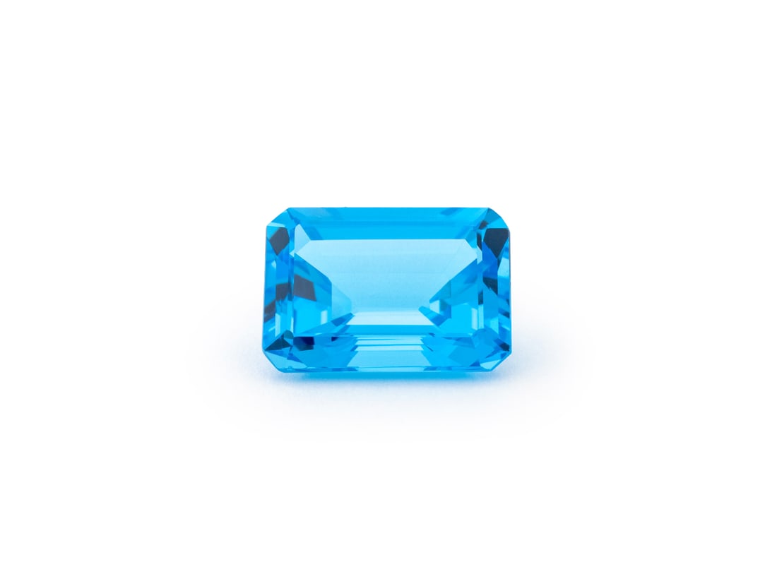 Swiss Emerald Cut Blue Topaz, 19.93 Carats: Swiss Blue Topaz Emerald Cut, 19.93 Carats, one loose rectangular step faceted gemstone approx. 17.9 x 13.0 mm., Measuring approx. 3/4" x 1/2", 19.93 carats. Provenance: From a New York City Collectio